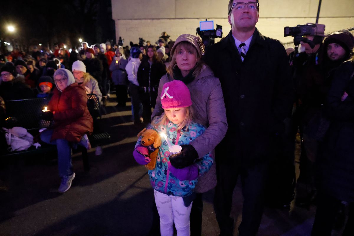A small child takes part in a candle light vigil in downtown Waukesha, Wis., Monday, Nov. 22, 2021 after an SUV plowed into a Sunday Christmas parade killing multiple people and injuring dozens.  (Jeffrey Phelps)
