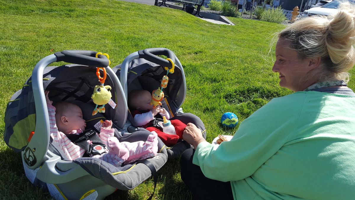 Linda Nelson plays with her  5-month-old twin daughters, Gabriella, left,  and Isabella on the lawn outside Pope Francis Haven. The family recently moved into a three bedroom apartment after years of homelessness. (Rachel Alexander / The Spokesman-Review)