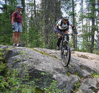 
Kirsty Exner, instructor for DevineRIDES in Rossland, British Columbia, works with one of the participants in her 2004 summer mountain biking camp.
 (Photo by Stacey Lighteourne / The Spokesman-Review)