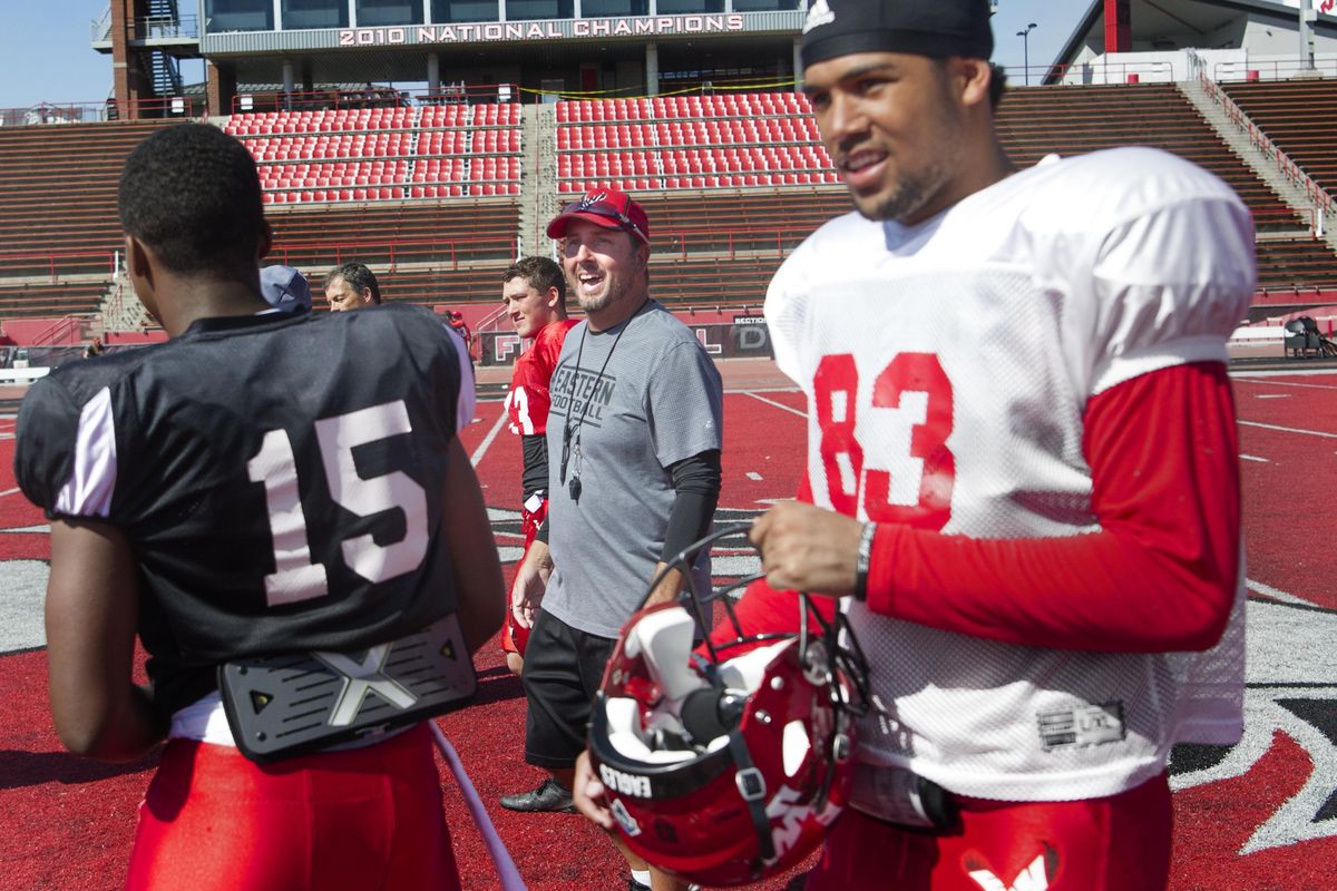 EWU head coach Beau Baldwin smiles with freshman quarterback Eric Barriere (15) and Talolo Limu-Jones (83) after a scrimmage on Friday, Aug. 26, 2016, at Roos Field in Cheney, Wash.  TYLER TJOMSLAND tylert@spokesman.com (Tyler Tjomsland / The Spokesman-Review)