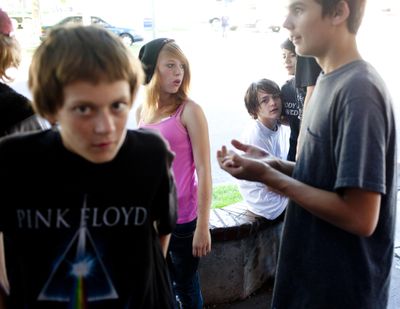 Kyler Kostelec, 15, white shirt sitting and his girlfriend Galina Hensz, 16, second from right, hang out with friends at “the planter,” a popular spot for homeless youth to hang out downtown on Aug. 27, 2013, in front of the Olive Garden on West Spokane Falls Boulevard. While the Olive Garden is now closed, Mosquito has been used to deter young people from loitering in front of the building that used to house it. That would change if the noise-emitting device is banned. (Tyler Tjomsland / The Spokesman-Review)