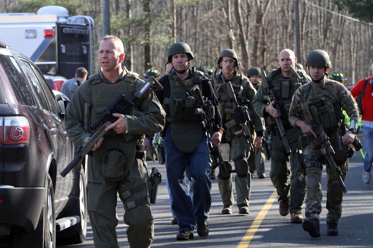 Heavily armed Connecticut State troopers are on the scene at Sandy Hook Elementary School in Newtown, Conn. where authorities say a gunman opened fire, leaving 27 people dead, including 20 children, Friday, Dec. 14, 2012. (Frank Jr. / The Journal News)