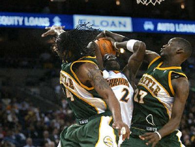 
Seattle's Chris Wilcox, left, and Johan Petro defend Golden State's Mickael Pietrus on Saturday. 
 (Associated Press / The Spokesman-Review)