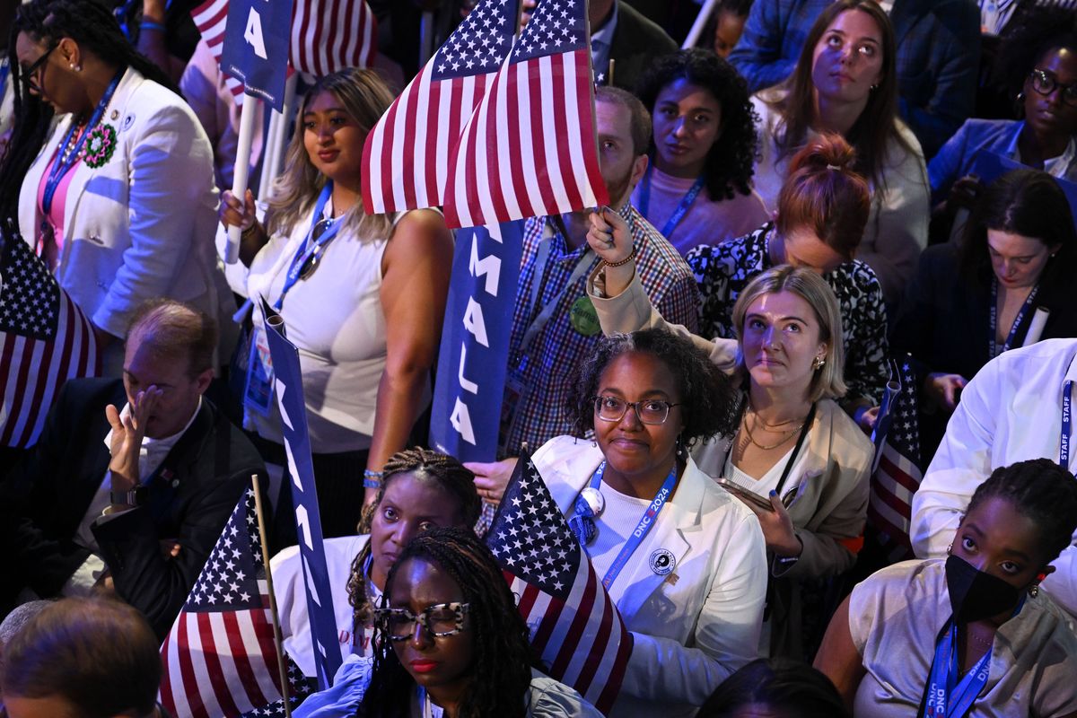 Attendees watch as Vice President Kamala Harris speaks during the final day of the Democratic National Convention at the United Center in Chicago on Aug. 22. (Joe Lamberti/For The Washington Post)