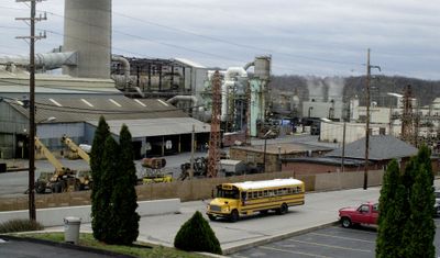 A school bus carrying students passes by the Doe Run Co. lead smelter in Herculaneum, Mo.  (FILE Associated Press / The Spokesman-Review)
