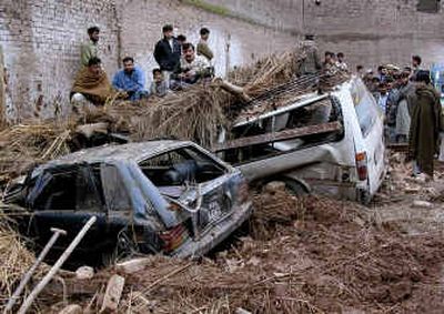 
People look at the damaged vehicles Saturday after a roof collapsed due to torrential rains in Peshawar, Pakistan.
 (Associated Press / The Spokesman-Review)