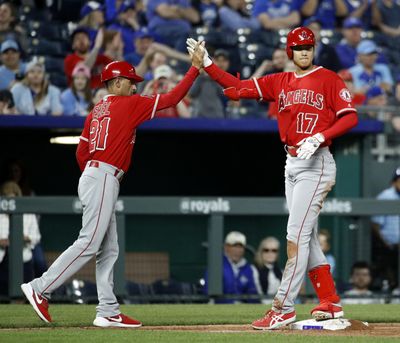 Los Angeles Angels' Shohei Ohtani (17) celebrates with third base coach Dino Ebel (21) after hitting a three-run triple during the seventh inning of a baseball game against the Kansas City Royals Thursday, April 12, 2018, in Kansas City, Mo. (Charlie Riedel / AP)