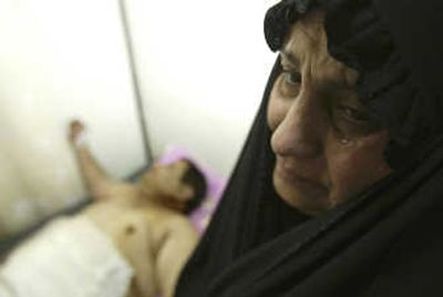 
A woman weeps during a visit to her injured husband at a hospital in Diwaniyah. The man was among civilians hurt during a mortar attack on military bases. Associated Press
 (Associated Press / The Spokesman-Review)