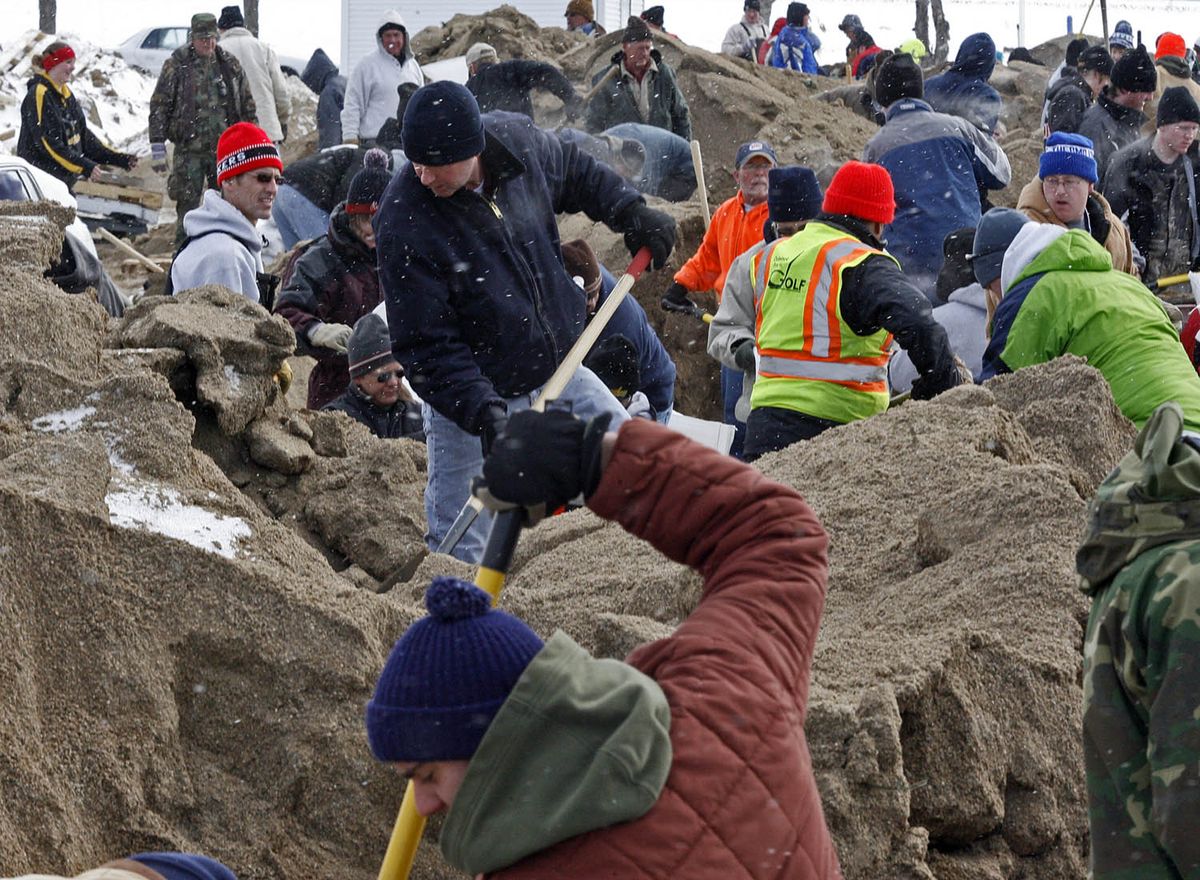 The Star Tribune  Volunteers shovel from piles of sand to provide sandbags for  residents Friday in North Moorhead, Minn. (Marlin Levison The Star Tribune / The Spokesman-Review)