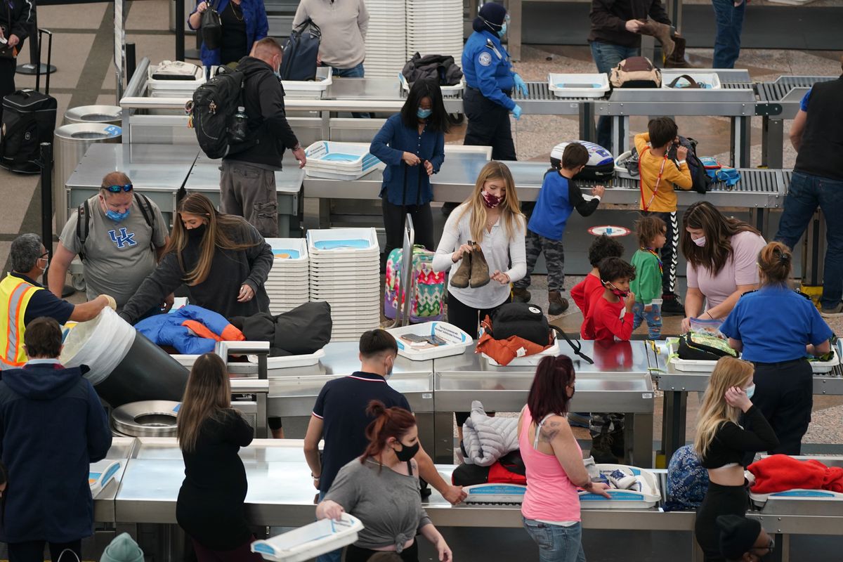 Travelers wear face masks while passing through the south security checkpoint in the main terminal of Denver International Airport on Tuesday in Denver. (David Zalubowski)