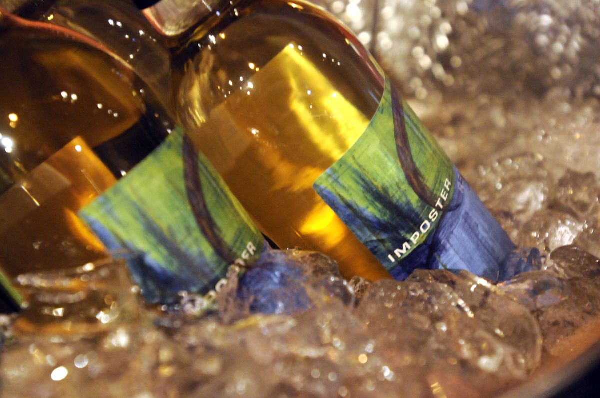 Bottles of a wine cryptically dubbed “Impostor” chill while visitors drop in for tastes at Caterina Winery on Saturday. (Jesse Tinsley / The Spokesman-Review)