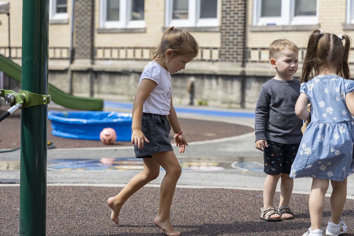 Valentyna Okonovska, left, and Vladyslav Rybak, second from left, both of whom recently arrived from Ukraine, play outside with other children on Aug. 4, 2022, during a summer camp at St. Nicholas Cathedral School in Chicago