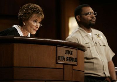 Judge Judy Sheindlin presides over a case as her bailiff Petri Hawkins Byrd listens on the set of her syndicated show