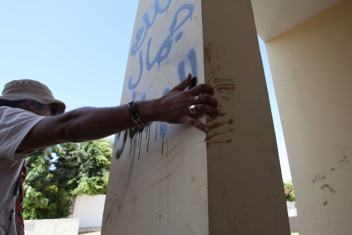 A Libyan man explains that the bloodstains on the column are from one the American staff members who grabbed the edge of the column while he was evacuated, after an attack that killed four Americans, including Ambassador Chris Stevens on the night of Tuesday, Sept. 11, 2012, in Benghazi, Libya, Thursday, Sept. 13, 2012.  The American ambassador to Libya and three other Americans were killed when a mob of protesters and gunmen overwhelmed the U.S. Consulate in Benghazi, setting fire to it in outrage over a film that ridicules Islam