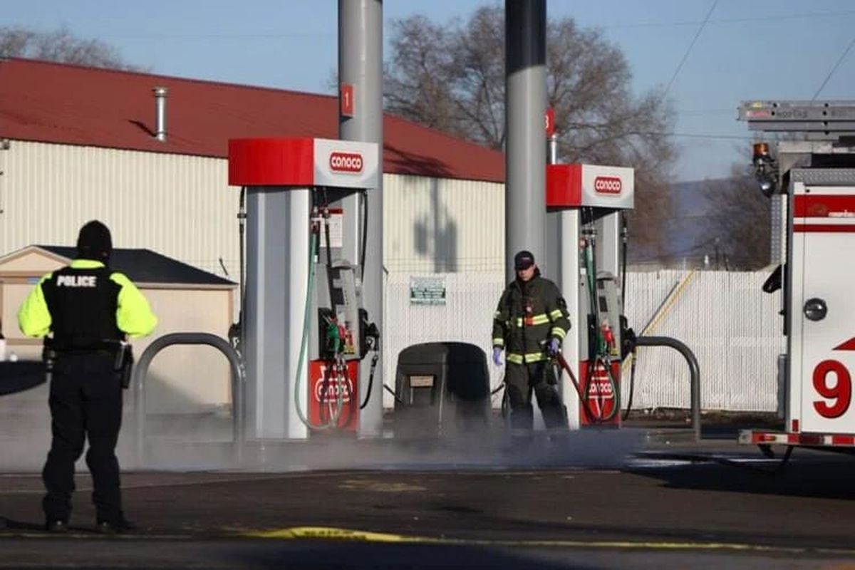 A Yakima firefighter washes blood off the ground following a shooting Tuesday at Circle K at the intersection of East Nob Hill Boulevard and 18th Street in Yakima.  (Emree Weaver/Yakima Herald-Republic)