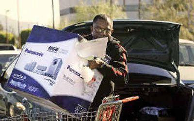 
A shopper in Burbank, Calif., loads a Christmas gift into his car on Christmas Eve.
 (Associated Press / The Spokesman-Review)