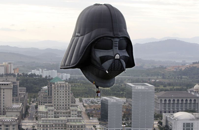 One of 22 hot air balloons rises at the start of the Putrajaya Hot Air Balloon Fiesta in Putrajaya, Malaysia, Thursday. Twenty-two balloons from  10 countries participated in the event. The Darth Vader balloon, made in 2007, is 86 feet high, including the basket.  (Associated Press)