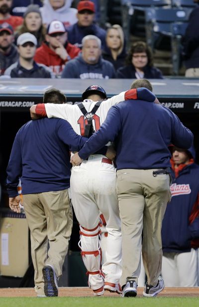 Cleveland catcher Yan Gomes is helped off the field after an injury on Saturday. (Associated Press)