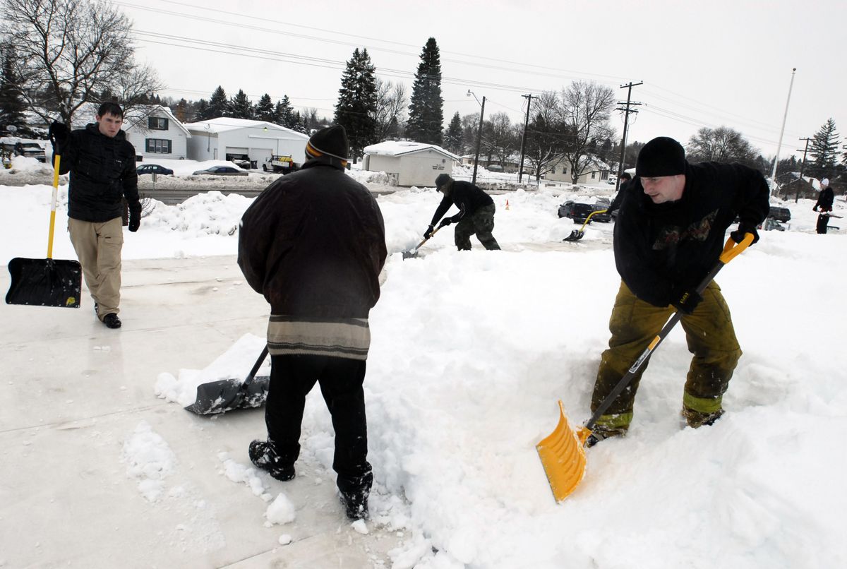 Shovelers remove the snow from the roof at Broadway Elementary School  Tuesday. (J. Rayniak / The Spokesman-Review)