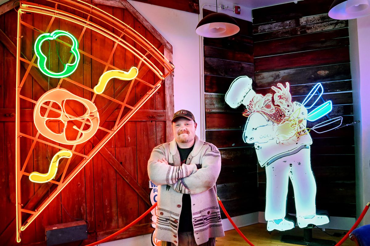 Local artist Chris Bovey poses for a photo on April 15 next to historical local neon signs he has restored and is displaying at the new site of Vintage Print + Neon inside the historic Boulevard Building at Indiana Avenue and Monroe Street in Spokane.  (Tyler Tjomsland/The Spokesman-Review)
