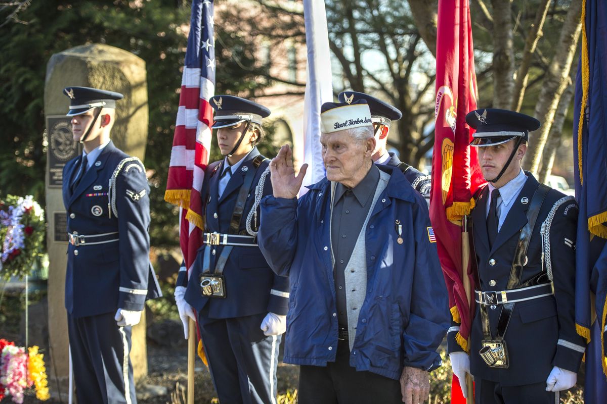 Pearl Harbor survivor Ray Garland, 95, salutes while gathered with members of the Fairchild Air Force Base Honor Guard, after a ceremony remembering the 76th anniversary of Pearl Harbor. Garland, the lone survivor of the local chapter, laid a wreath during the ceremony at the memorial , left, outside the Spokane Veterans Memorial Arena, Thursday, Dec. 7, 2017. (Dan Pelle / The Spokesman-Review)
