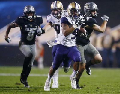 Washington running back Myles Gaskin, front, dashes past Colorado defensive backs Trey Udoffia, left, and Ryan Moeller on the way to a touchdown during the second half of an NCAA college football game l Saturday, Sept. 23, 2017, in Boulder, Colo. Washington won 37-10. (David Zalubowski / Associated Press)