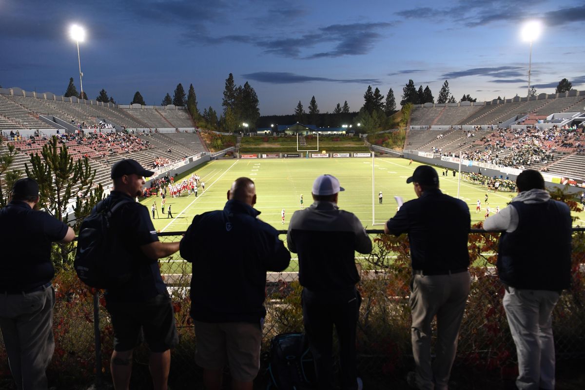 Football coaches line up on the hill overlooking Joe Albi Stadium and wait for the first game to end before joining their team on the field Thursday, Sept. 27, 2018. (Jesse Tinsley / The Spokesman-Review)
