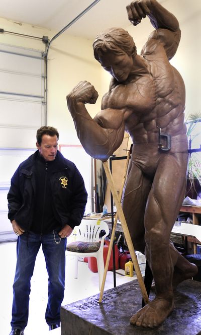 Pumping clay: Arnold Schwarzenegger goes over every detail as he gets the first in-person-look at the larger than life clay sculpture artist Ralph Crawford is sculpting for him Wednesday in Lewiston. Once complete the statue will be bronzed and sent to Austria to be displayed in Schwarzenegger’s hometown. (Associated Press)