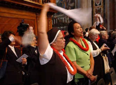 
Sister Frances Therese Souza, a nurse at Kalaupapa, waves a scarf, alongside Sister Davilyn Ah Chick, of Oahu, at the end of a Mass and a beatification ceremony for Mother Marianne Cope, Saturday, at St. Peter's Basilica in Vatican City. 
 (Associated Press / The Spokesman-Review)