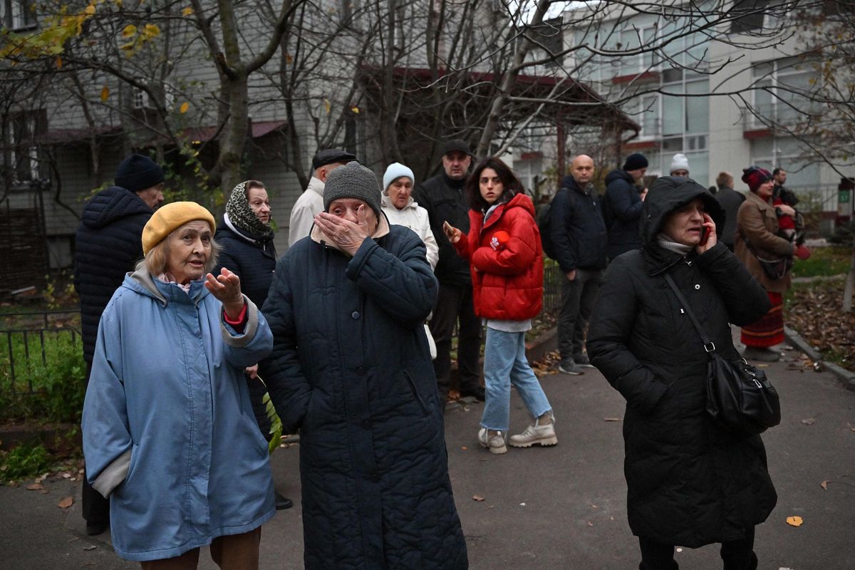 Local residents look on as Ukrainian firefighters intervene at the scene where a Russian missile fragment fell near a residential building causing fire in the centre of the Ukrainian capital of Kyiv on Nov. 15. The Ukrainian presidency said that the situation across the country was “critical” after a fresh wave of Russian missiles battered energy facilities, forcing emergency shutdowns and plunging parts of the capital into darkness.  (Sergei Supinsky/AFP/Getty Images/TNS)