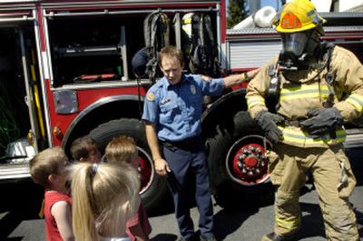 
Spokane Valley firefighters Bob Leaming, left, and Bill Henrichs show a group of preschool children what a firefighter looks like wearing personal protective gear, during a recent morning tour of Station 1. Fire officials say fire prevention education is key in decreasing fires.
 (Holly Pickett / The Spokesman-Review)