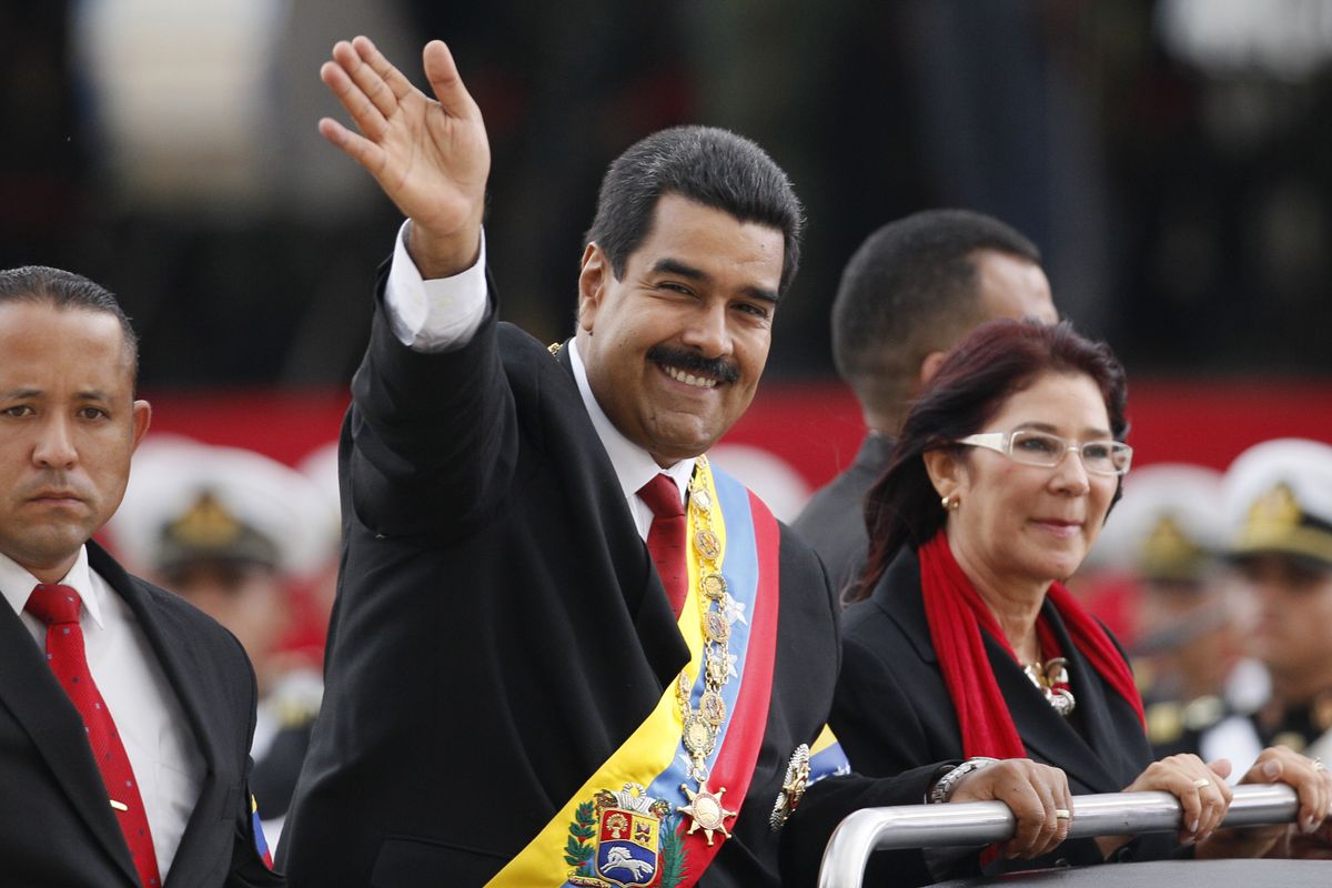 Venezuela’s President Nicolas Maduro waves from a vehicle, next to his companion Cilia Flores, during a ceremony in Caracas, Venezuela, on Friday. (Associated Press)