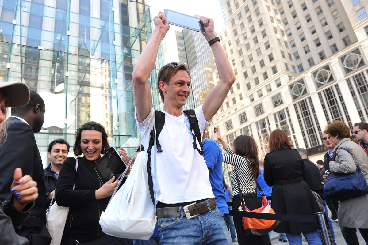 Mike Heinsius, of Rotterdam, Netherlands, holds up his new iPad outside the Apple Store on Fifth Avenue in New York on Saturday, April 3, 2010. (Diane Bondareff / Associated Press)