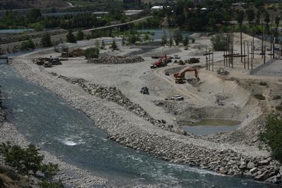 Heavy machinery is being used to dig a channel for water to flow in the lower Chelan Gorge at Chelan Falls, Wash., as seen here July 8. Chelan County PUD is working on a project to keep a year-round river flow in Chelan Gorge and expand fish-spawning habitat in the lower gorge.  (Associated Press / The Spokesman-Review)