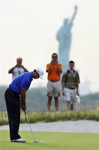 Tiger Woods putts on the second green, with the Statue of Liberty seen in the background, during a practice round for The Barclays golf tournament on Wednesday, Aug. 26, 2009, in Jersey City, N.J. (AP Photo/Mel Evans) (Mel Evans / AP News)