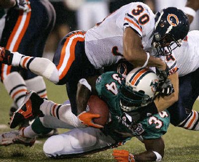 
Chicago's Mike Brown (30) and Brian Urlacher haul down Miami running back Ricky Williams on Monday night.
 (Associated Press / The Spokesman-Review)