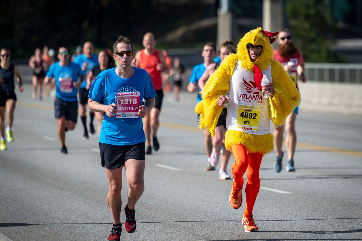 ABOVE: Kyle McNaught-Davis, in a chicken suit, crosses TJ Meenach Bridge during Bloomsday on Sunday in Spokane. “The good part is everyone’s yelling at you,” McNaught-Davis said.  (COLIN MULVANY/THE SPOKESMAN-REVIEW)