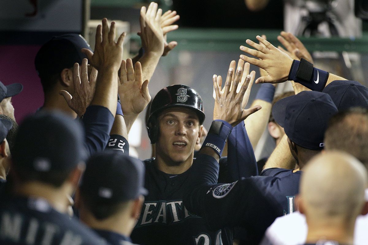 Seattle’s Logan Morrison, center, is greeted by his teammates after scoring on a Mike Zunino double in the fifth inning. (Associated Press)