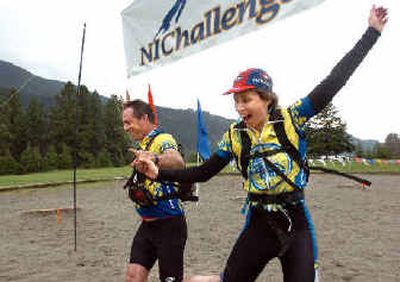 
Brenda Christiansen, right, of Athol, and Bill Hinkley of Victoria, B.C., celebrate their crossing the finish line during the NIChallenge race Saturday. It's the first of its kind in North Idaho – a team cross-country adventure race in which participants compete in running, kayaking and biking around Farragut State Park. 
 (The Spokesman-Review)