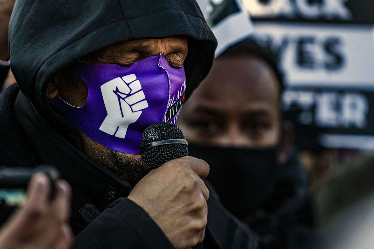Protesters, including the father of Dolal Idd, Bayle Adod Gelle, holding microphone, gather during a rally against police brutality, Sunday, Jan. 3, 2021, in Minneapolis, at the gas station where Dolal Idd was shot by Minneapolis police several days earlier.  (Richard Tsong-Taatarii)