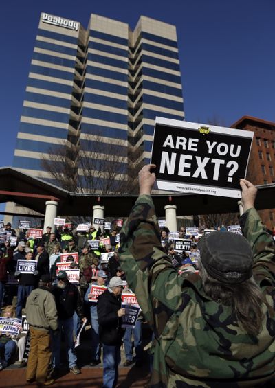 In this Feb. 13 photo, a member of the United Mine Workers of America, holds up a sign as he takes part in a protest outside the St. Louis headquarters of Peabody Energy. (Associated Press)