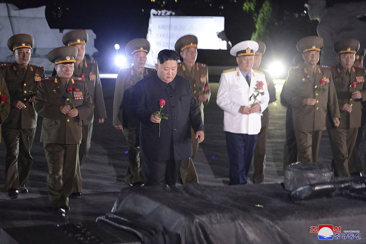 In this undated photo provided on Monday, July 27, 2020, by the North Korean government, North Korean leader Kim Jong Un, center, with military officers in uniforms prepares to lay a flower to the Fatherland Liberation War Martyrs