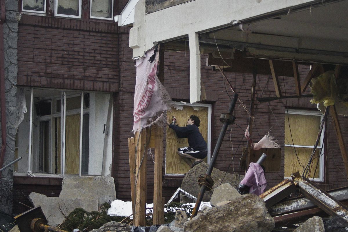 Marcus Konner, 22, boards his home in the aftermath of a storm surge from Hurricane Sandy, Tuesday, Oct. 30, 2012, in Coney Island