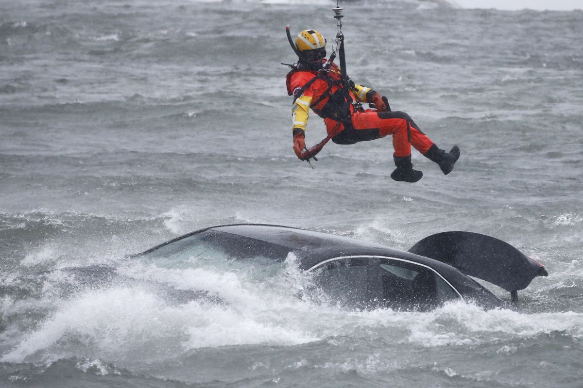 A U.S. Coast Guard diver is lowered from a hovering helicopter to pull a body from a submerged vehicle stuck in rushing rapids just yards from the brink of Niagara Falls, Wednesday, Dec. 8, 2021, in Niagara Falls, N.Y.  (Jeffrey T. Barnes)