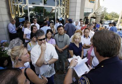 Customers of IndyMac Federal Bank listen to Burbank, Calif., Police Sgt. Matthew Ferguson’s instructions as he reads names from a sign-up sheet while they wait in line to withdraw money from the failed financial institution on Monday. The bank was helping 10 customers per hour and the list was at least 200 names long soon after it opened its doors.  (Associated Press / The Spokesman-Review)