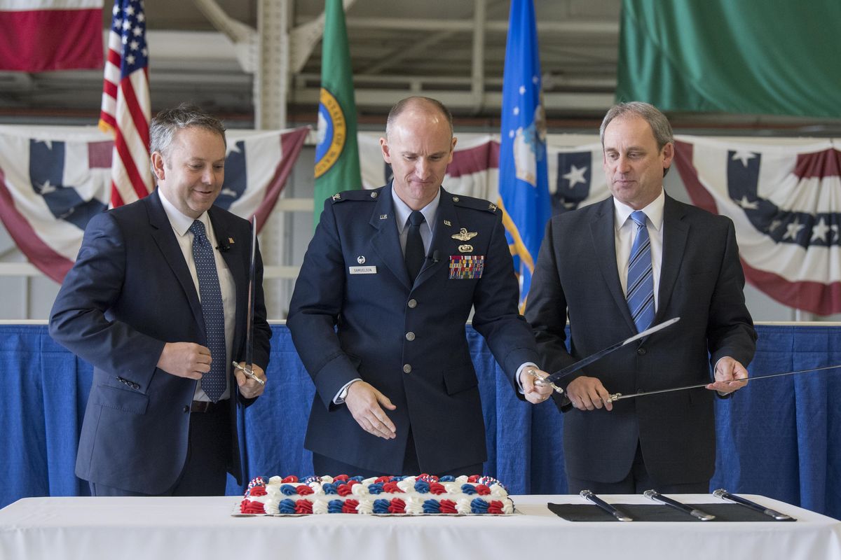 Spokane Mayor David Condon, left, Col. Ryan Samuelson, and Todd Mielke of Greater Spokane Inc. prepare to cut a cake celebrating the 75th anniversary of Fairchild Air Force Base on Wednesday at a ceremony at the base. (Jesse Tinsley / The Spokesman-Review)