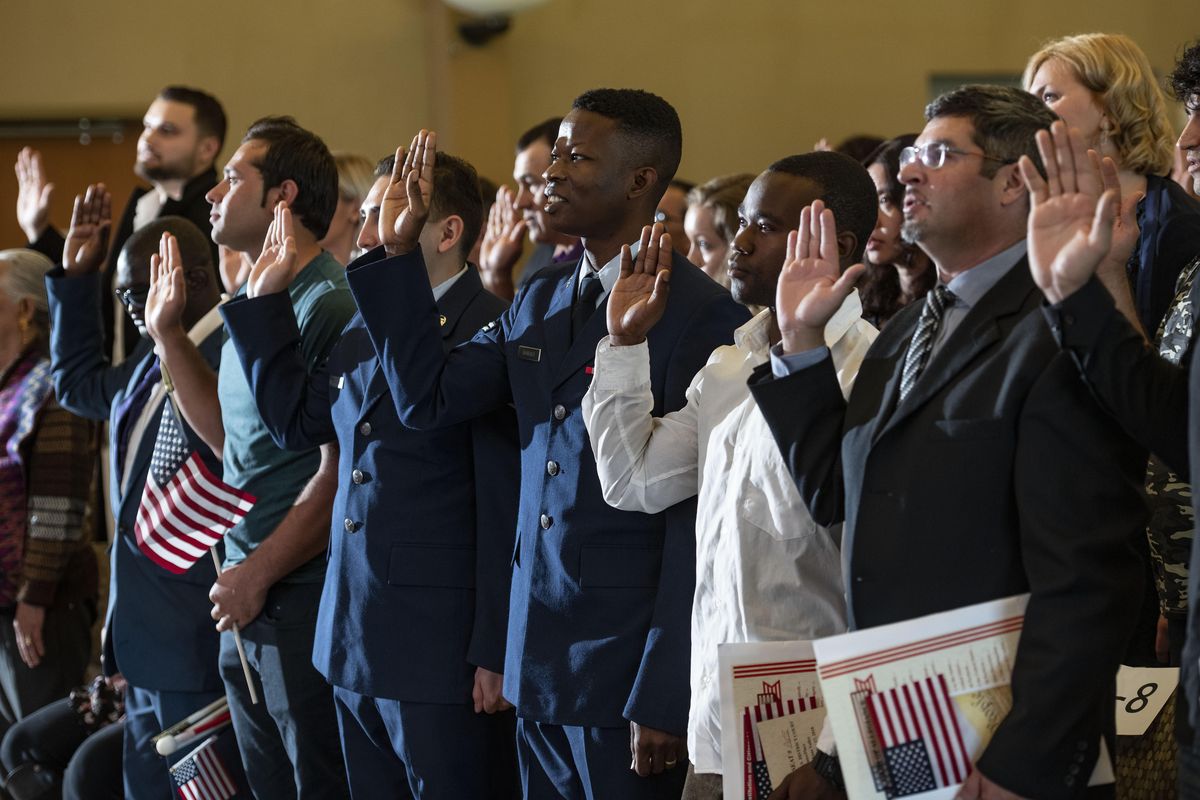 One hundred people from more than 30 countries raise their right hand and swear an oath to the United States, thus becoming U.S. citizens during a ceremony at CenterPlace with U.S. District Judge Thomas Rice on Monday, Sept. 17, 2018. (Colin Mulvany / The Spokesman-Review)