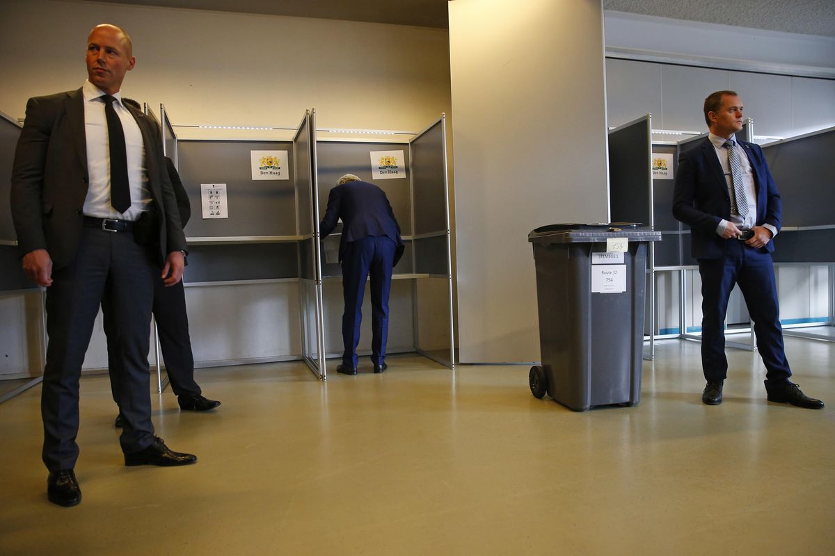 Security guards look on as firebrand anti-Islam lawmaker Geert Wilders, center, prepares to cast his vote for the Dutch general election in The Hague, Netherlands, Wednesday, March 15, 2017. (Peter Dejong / Associated Press)