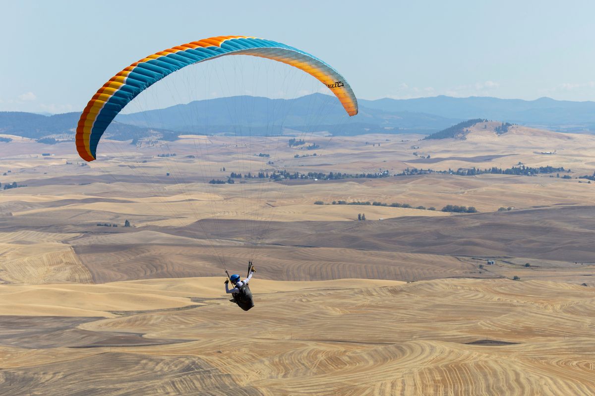 Chelsea Jahant-Miller, of Spokane, flies her paraglider after taking off from Steptoe Butte in Colfax on Saturday. Jahant-Miller was participating in a fly-in held to celebrate 50 years of hang gliding at Steptoe Butte. (Geoff Crimmins/For the Spokesman-Review)