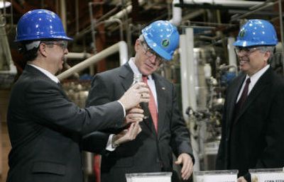 
Dr. Michael Pachpeco, left, of the National Bio Energy Center, shows President Bush a bottle of ethanol during a tour of the National Renewable Energy Laboratory, as Dr. Dan Arvizu looks on. 
 (Associated Press / The Spokesman-Review)